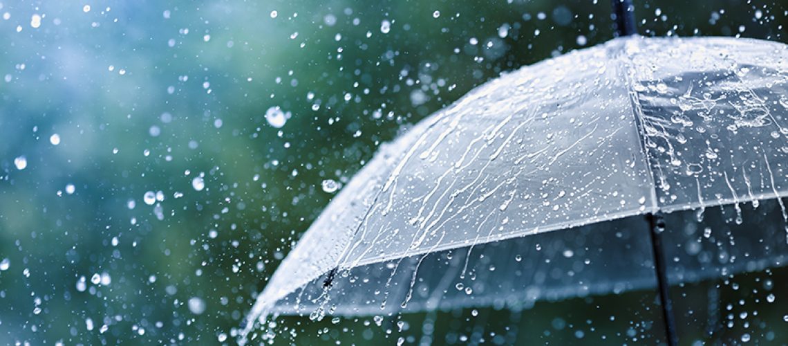Transparent umbrella under heavy rain against water drops splash background. Rainy weather concept.