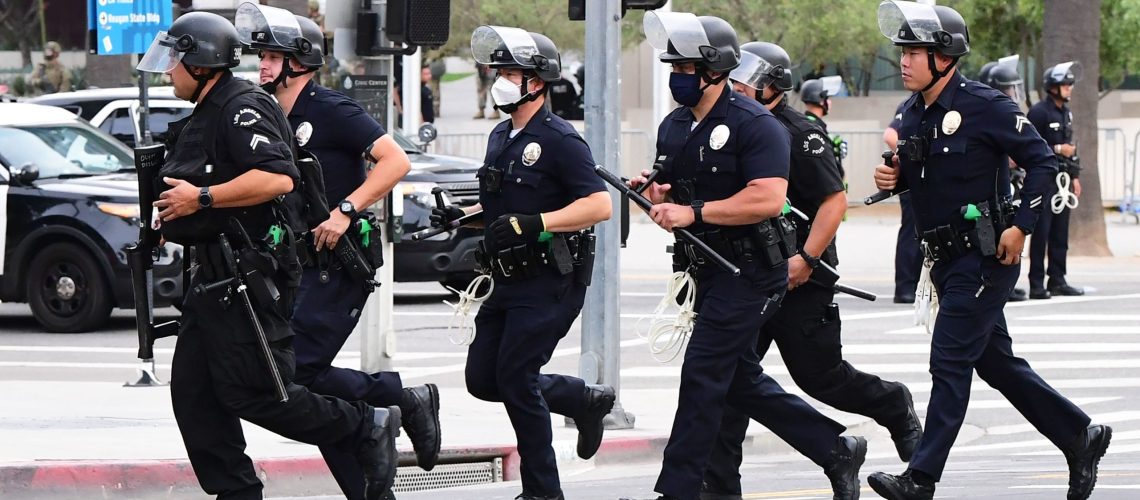 Los Angeles police officers run to formation during a protest on June 1.